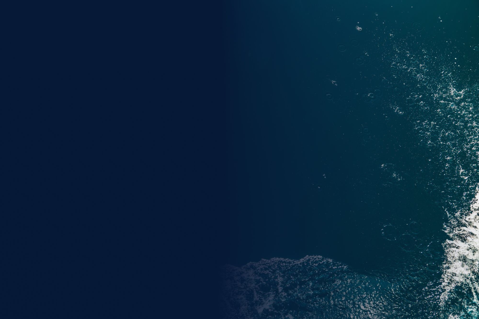 birdseye view of ocean with waves in corner